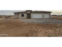 A single-story stucco home with a two car garage and desert landscaping at 25519 W Brookhart Way, Wittmann, AZ 85361