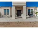 Modern front entry with a black door and a spacious porch at 34150 W Corleone Dr, Maricopa, AZ 85138