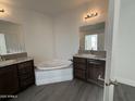 Bathroom with corner tub, dark brown vanity, and double sinks at 38007 W Mcdowell Rd, Tonopah, AZ 85354