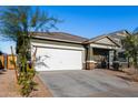 Single-story house with a white garage door and landscaping at 4718 N 193Rd Dr, Litchfield Park, AZ 85340