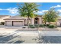 Tan, one-story house with a two-car garage and arched entryway at 6429 E Everett Dr, Scottsdale, AZ 85254