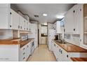 Clean kitchen featuring wood countertops and white cabinets at 8103 E Southern Ave # 39, Mesa, AZ 85209