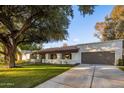 Front view of a charming house with a brown garage door and manicured lawn at 8614 E Appaloosa Trl, Scottsdale, AZ 85258