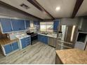 Bright kitchen with blue cabinets, stainless steel appliances, and wood-look floors at 9302 E Broadway Rd # 24, Mesa, AZ 85208