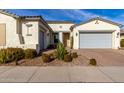 Bright and airy home exterior with a welcoming front porch and two-car garage at 10712 E Trillium Ave, Mesa, AZ 85212