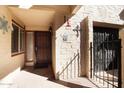 Front entry with a wooden door and a security gate at 16615 N 30Th Ave, Phoenix, AZ 85053