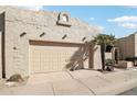 Tan stucco house with a two-car garage and gated entry at 16615 N 30Th Ave, Phoenix, AZ 85053