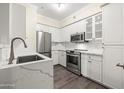 Modern kitchen features stainless steel appliances, white cabinetry, and quartz countertops at 1701 E Colter St # 223, Phoenix, AZ 85016