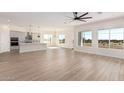 Open-concept living space with tile floors, large windows, and modern lighting fixtures at 17017 W Baker Dr, Surprise, AZ 85387