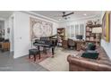 Home office featuring a grand piano, built-in shelves, and a comfortable seating area at 19447 S 209Th Pl, Queen Creek, AZ 85142