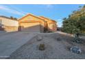 Front view of a charming house with a two-car garage and small front yard at 23699 N Oasis Blvd, Florence, AZ 85132