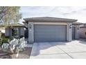 House exterior with gray garage doors and landscaping at 26175 W Firehawk Dr, Buckeye, AZ 85396