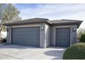 Two-car garage with gray doors and exterior lighting at 26175 W Firehawk Dr, Buckeye, AZ 85396