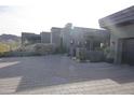 Modern home exterior with gray stone and paver driveway at 41104 N 96Th St, Scottsdale, AZ 85262