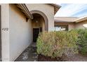 Front entry with arched doorway and well-manicured shrubbery at 4212 S 78Th Ln, Phoenix, AZ 85043