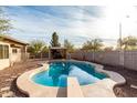 Inviting kidney-shaped pool with diving board and covered patio at 4212 S 78Th Ln, Phoenix, AZ 85043