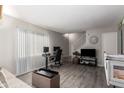 Living room features laminate flooring, a staircase, and a wall-mounted TV at 4240 N 67Th Ln, Phoenix, AZ 85033