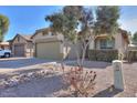 House exterior with a two-car garage, landscaping, and a driveway at 45091 W Cypress Ln, Maricopa, AZ 85139