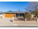 House exterior featuring a brown garage door, brick accents, and a manicured lawn at 5210 W Ironwood Dr, Glendale, AZ 85302