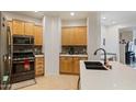 Well-equipped kitchen with light wood cabinets and granite countertops at 6233 W Maya Dr, Phoenix, AZ 85083