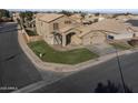 Aerial view of a two-story home with a spacious three-car garage and a green lawn in a quiet neighborhood at 638 W Nido Ave, Mesa, AZ 85210