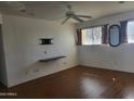 Bedroom with wood-look flooring, ceiling fan, and TV wall mount at 720 N 82Nd St # E210, Scottsdale, AZ 85257