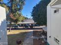 View of apartment building parking lot with cars parked under covered structure at 720 N 82Nd St # E210, Scottsdale, AZ 85257