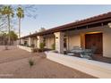 House with covered patio, metal table and chairs, and mature trees at 12211 N 57Th St, Scottsdale, AZ 85254