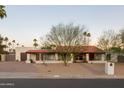 Ranch style home with red tile roof, landscaping, and long driveway at 12211 N 57Th St, Scottsdale, AZ 85254