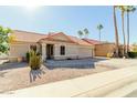 Tan house with a red tile roof, a two-car garage, and palm trees at 1237 E Heather Ave, Gilbert, AZ 85234