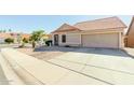 Tan house with a red tile roof and a two-car garage, viewed from the street at 1237 E Heather Ave, Gilbert, AZ 85234