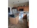 Traditional style kitchen with a center island, tile flooring, stainless steel refrigerator and laminate countertops at 1259 E Canyon Trl, San Tan Valley, AZ 85143