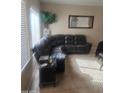 View of living room with tile floor, neutral paint and a comfortable black leather couch at 1259 E Canyon Trl, San Tan Valley, AZ 85143