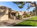 Tan stucco condo building with walkway, landscaping, and patio at 14300 W Bell Rd # 207, Surprise, AZ 85374