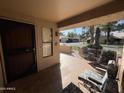 Covered patio with tile flooring, wrought iron furniture, and access to the front door at 14300 W Bell Rd # 207, Surprise, AZ 85374