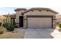 Front view of a tan house with a two-car garage and cacti at 157 W Latigo Cir, San Tan Valley, AZ 85143