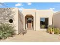 Inviting entryway to a single-story home with a wooden door and large windows at 18702 E Gemmill Dr, Rio Verde, AZ 85263