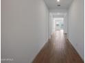 Inviting hallway with wood-look floors and bright, neutral walls leading to the home's interior at 22663 E Happy Rd, Queen Creek, AZ 85142