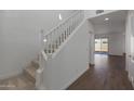 Bright entryway with a staircase featuring white railings, leading to the upper level at 23128 E Watford Dr, Queen Creek, AZ 85142