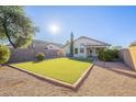 Artificial turf backyard with covered patio and citrus trees at 34403 N Damietta Trl, San Tan Valley, AZ 85143