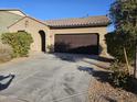 House exterior featuring a two-car garage and well-maintained landscaping at 36850 W Nola Way, Maricopa, AZ 85138