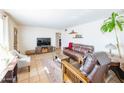 Bright living room with leather furniture and large TV at 3750 W Marshall Ave, Phoenix, AZ 85019