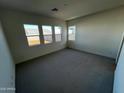 Bright bedroom with gray carpet and three large windows at 3752 W Antelope Way, San Tan Valley, AZ 85144