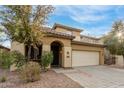 Two-story house with tan exterior, two-car garage, and landscaped yard at 8841 W Cordes Rd, Tolleson, AZ 85353