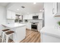 Modern white kitchen with an island and stainless steel appliances at 11225 S Tomah St, Phoenix, AZ 85044