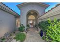 Elegant entryway with arched entry, stone tile flooring, and lush landscaping at 12657 N 135Th St, Scottsdale, AZ 85259