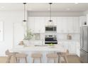 Modern kitchen with white cabinets, quartz countertops, and an island with seating at 16640 N Dante Way, Maricopa, AZ 85138