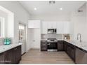 Modern kitchen featuring dark cabinetry, stainless steel appliances, and quartz countertops at 1841 E Secretariat Dr, Tempe, AZ 85284