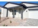 Home's exterior features a covered porch, dark gray pillars, and a two-car garage at 22910 E Alyssa Rd, Queen Creek, AZ 85142