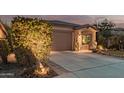 Single-story home with a two-car garage and lush landscaping with accent lighting at 337 W Stanley Ave, San Tan Valley, AZ 85140